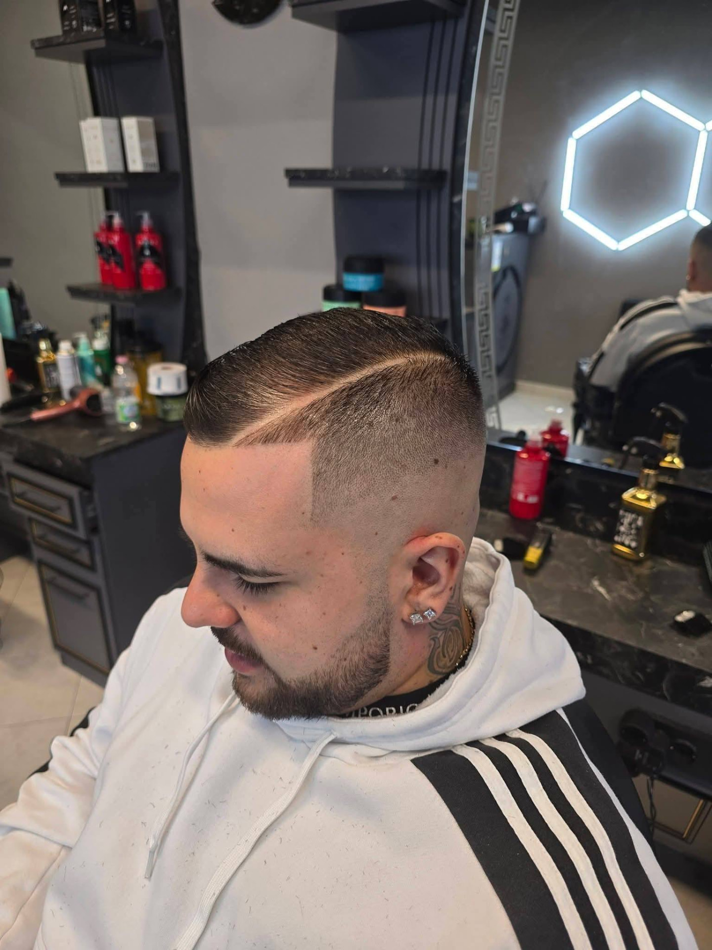 Taglio pettinato con riga laterale e barba curata